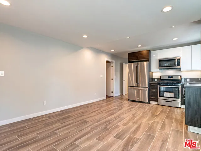 a view of kitchen with refrigerator microwave and stove