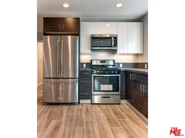 a kitchen with stainless steel appliances a refrigerator and a stove top oven