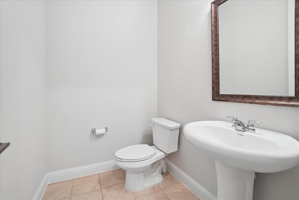 2721 Rotherham Street Prosper, TX 75078 - Photo 23 of 37 a white toilet sitting next to a bathroom sink