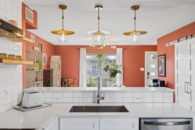 a view of a kitchen with a sink and chandelier