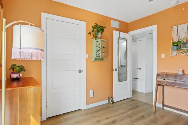 a view of a hallway with wooden floor and dining room