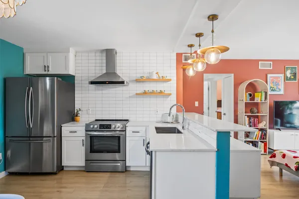 a kitchen with stainless steel appliances granite countertop a refrigerator sink and stove