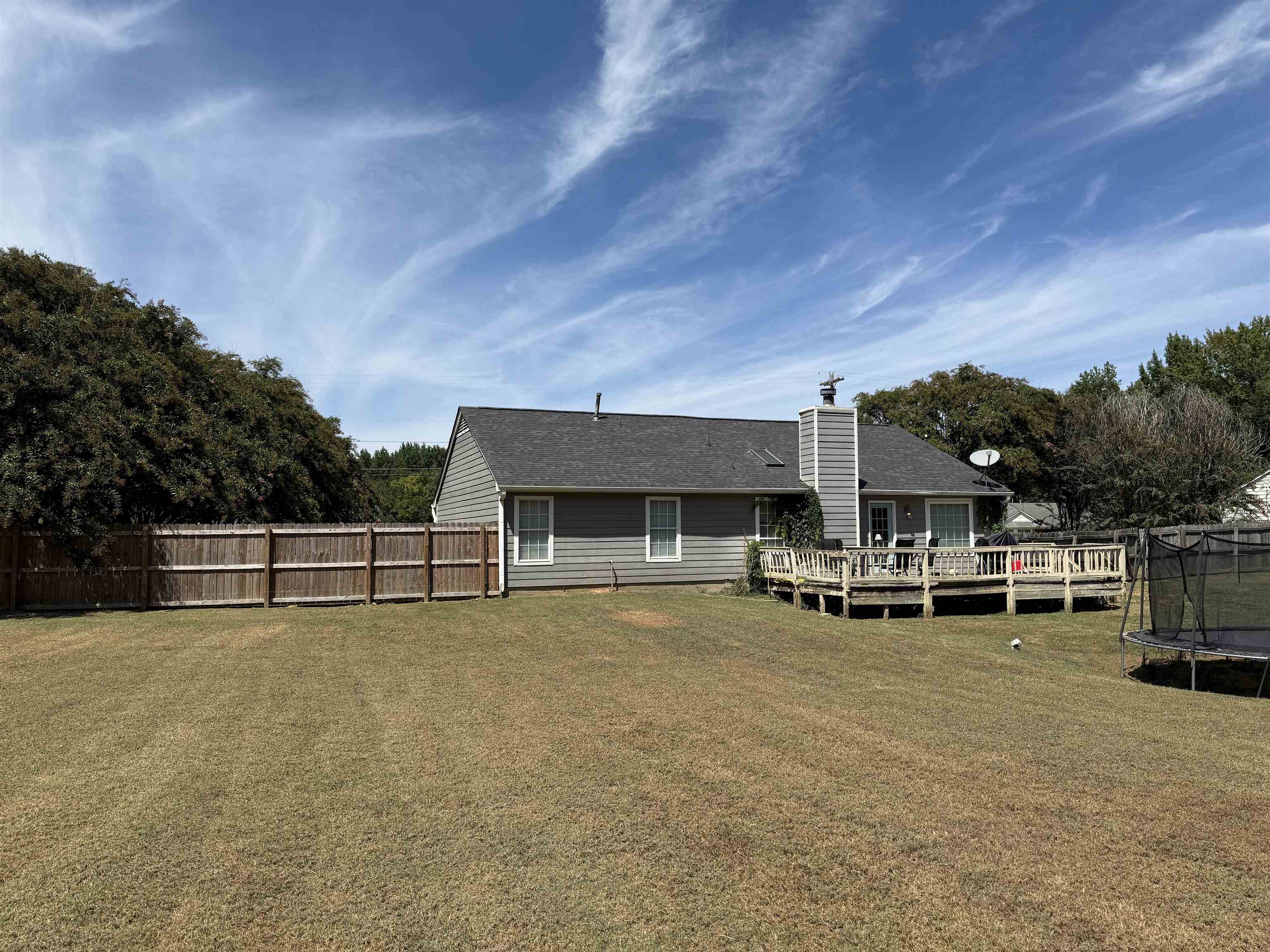 663 Tracy Road Millington, TN 38053 - Photo 17 of 21 Back of house with a trampoline, a deck, a chimney, and a shingled roof
