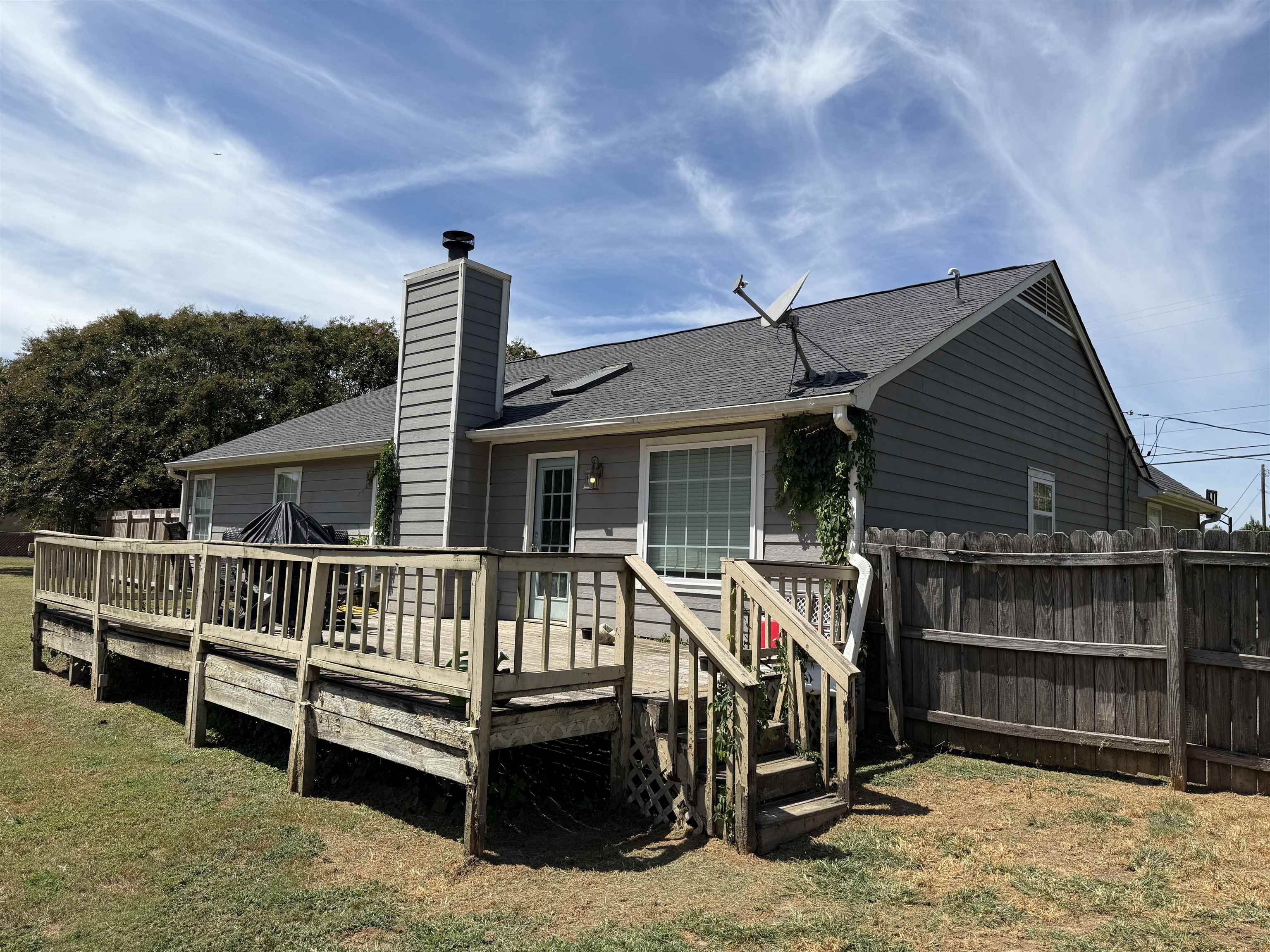 663 Tracy Road Millington, TN 38053 - Photo 19 of 21 Rear view of house featuring a shingled roof, a chimney, and a wooden deck
