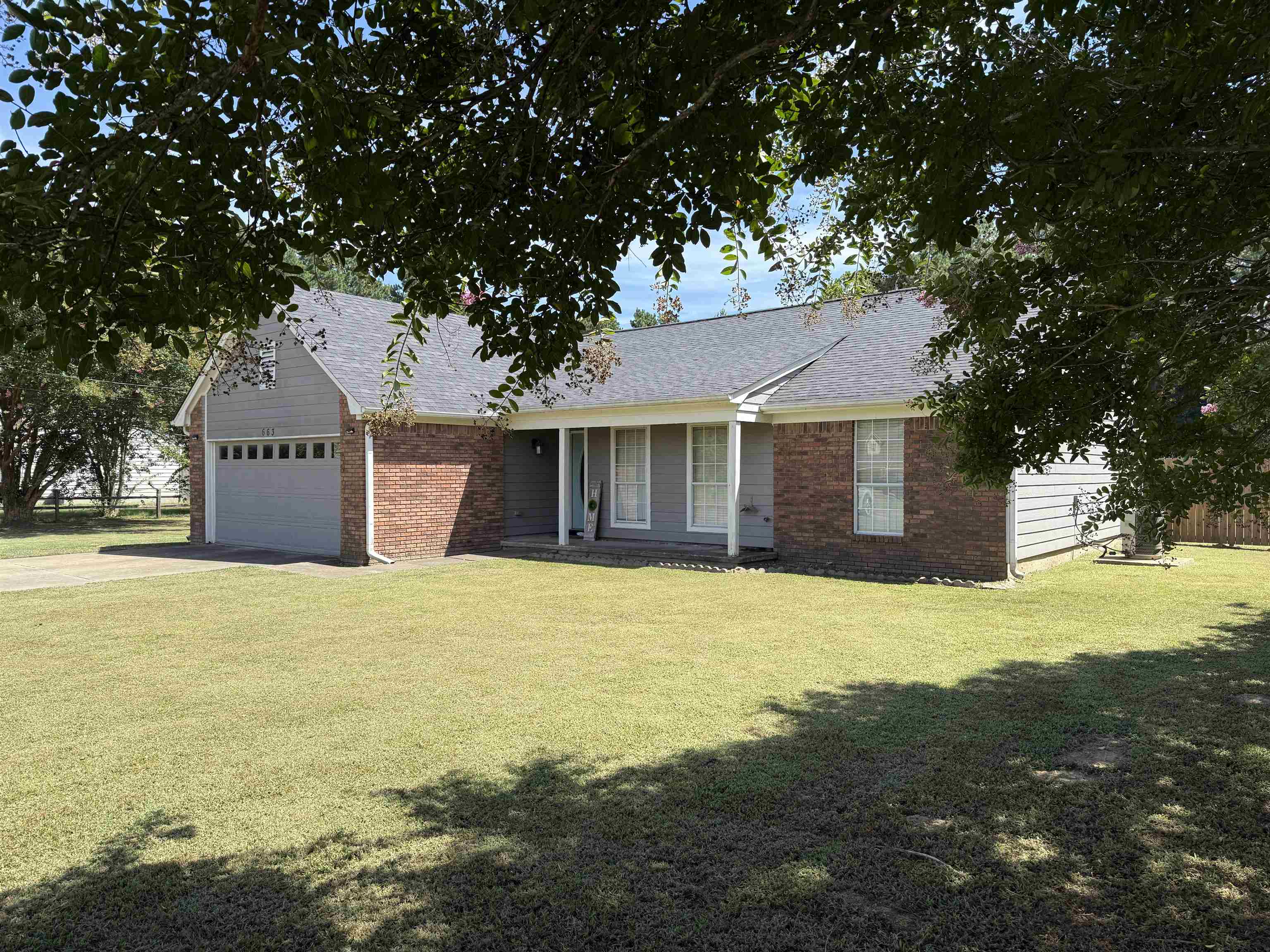 663 Tracy Road Millington, TN 38053 - Photo 3 of 21 Ranch-style home featuring an attached garage, driveway, a shingled roof, and a front lawn