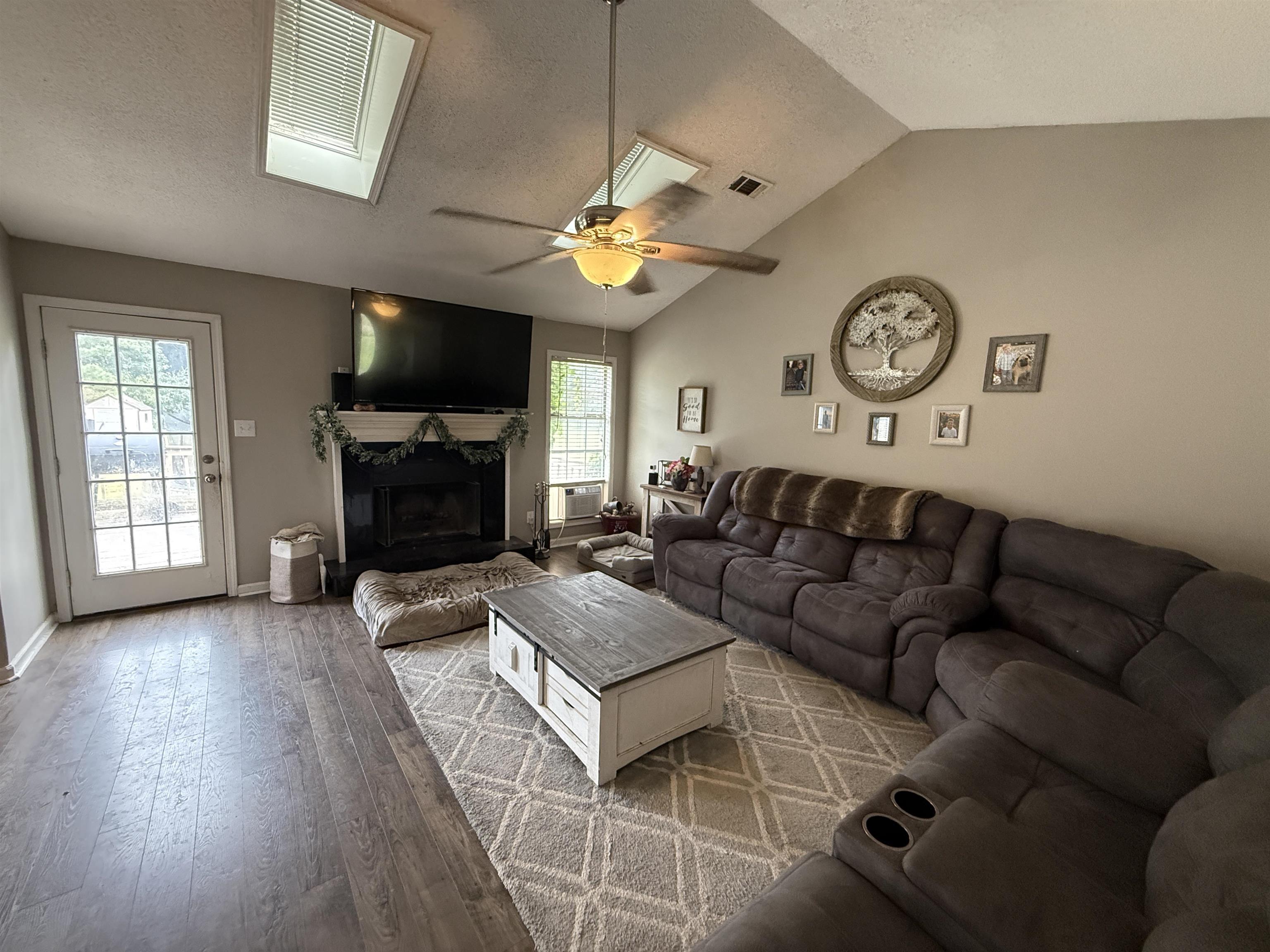 663 Tracy Road Millington, TN 38053 - Photo 9 of 21 Living area with lofted ceiling, a textured ceiling, hardwood / wood-style floors, a premium fireplace, and ceiling fan