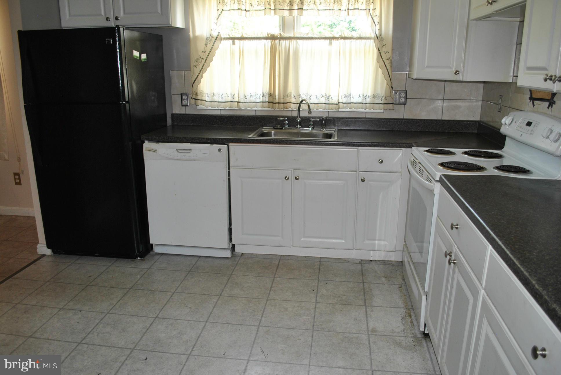 1941 Winder Road Baltimore, MD 21244 - Photo 8 of 22 a kitchen with granite countertop a refrigerator a sink and wooden cabinets