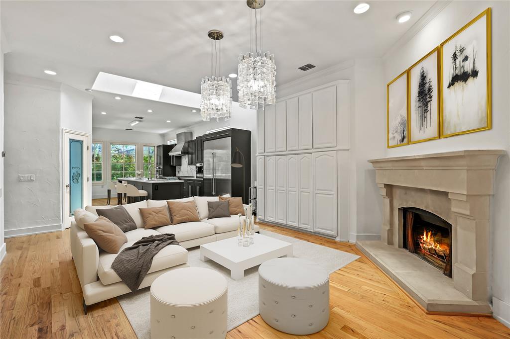 11911 Edgestone Road Dallas, TX 75230 - Photo 6 of 40 Living area with recessed lighting, light wood-style flooring, ornamental molding, a skylight, and a fireplace