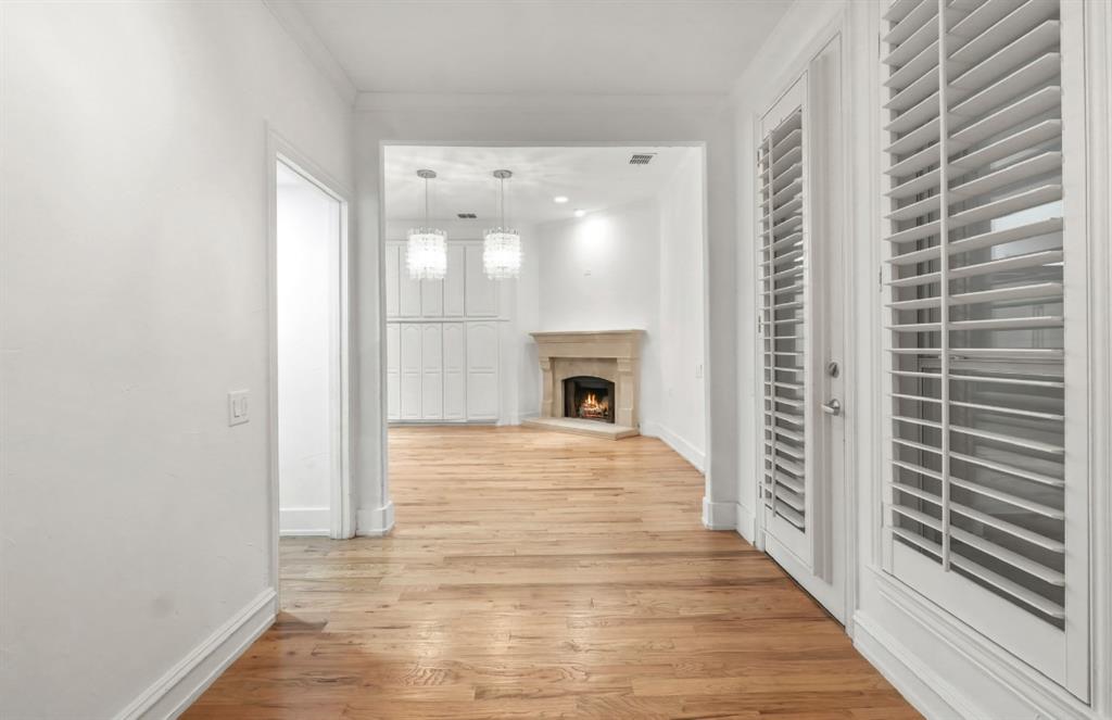 11911 Edgestone Road Dallas, TX 75230 - Photo 10 of 40 Corridor with light wood-type flooring and crown molding