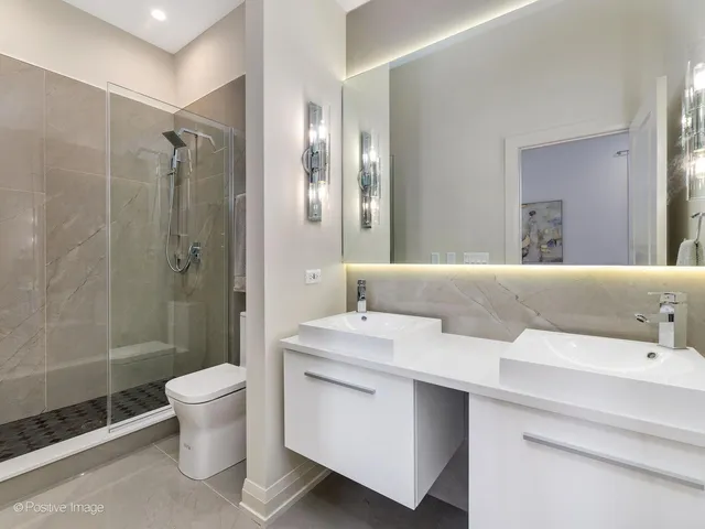 a bathroom with a double vanity sink toilet and shower