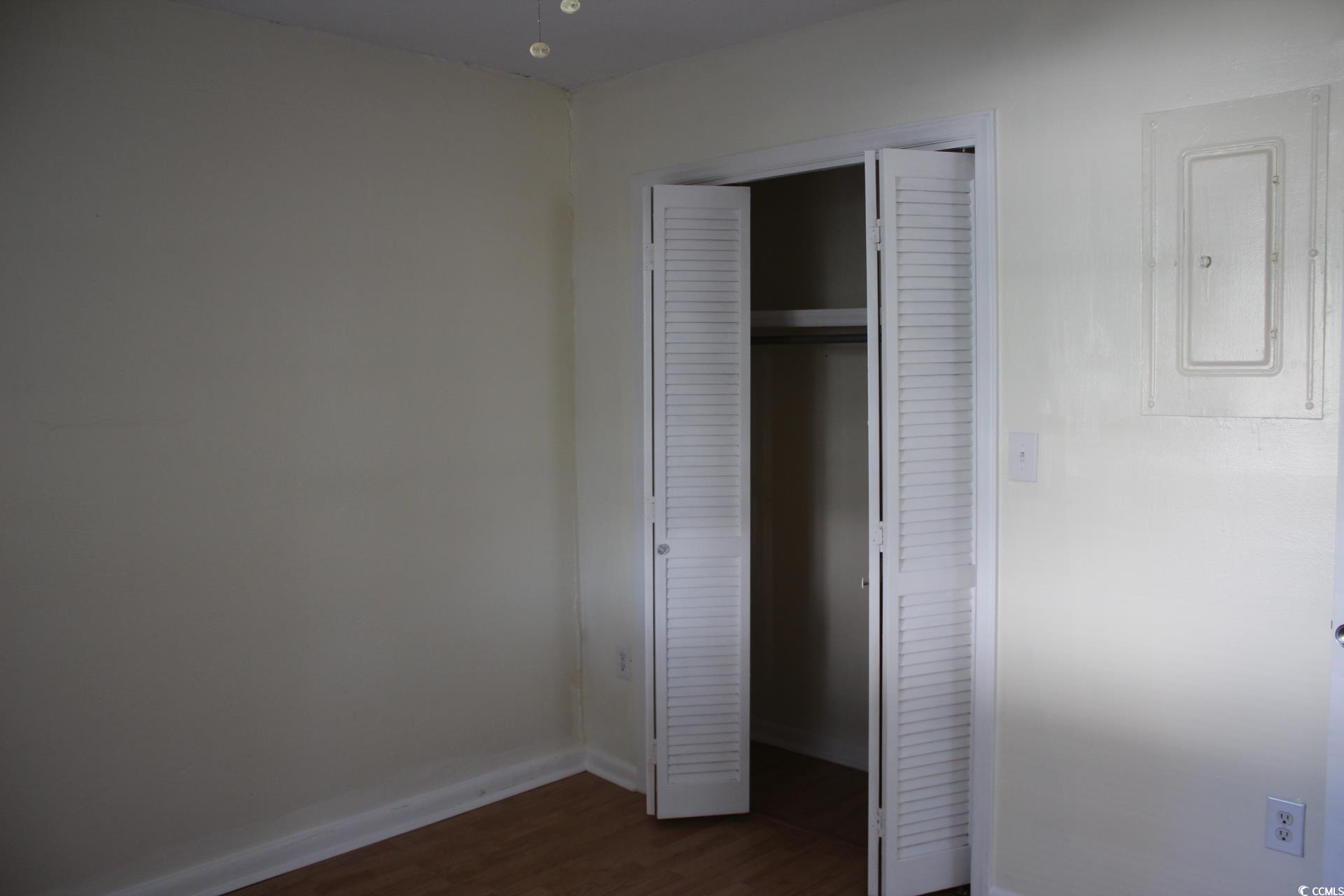 1500 Chester Street, Unit 1 Myrtle Beach, SC 29577 - Photo 7 of 9 Unfurnished bedroom with electric panel, dark wood-style floors, and a closet