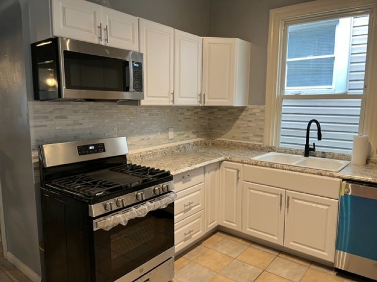 7927 South Burnham Avenue Chicago, IL 60617 - Photo 5 of 11 a kitchen with granite countertop white cabinets stainless steel appliances and a sink