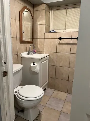 a bathroom with a toilet sink and mirror