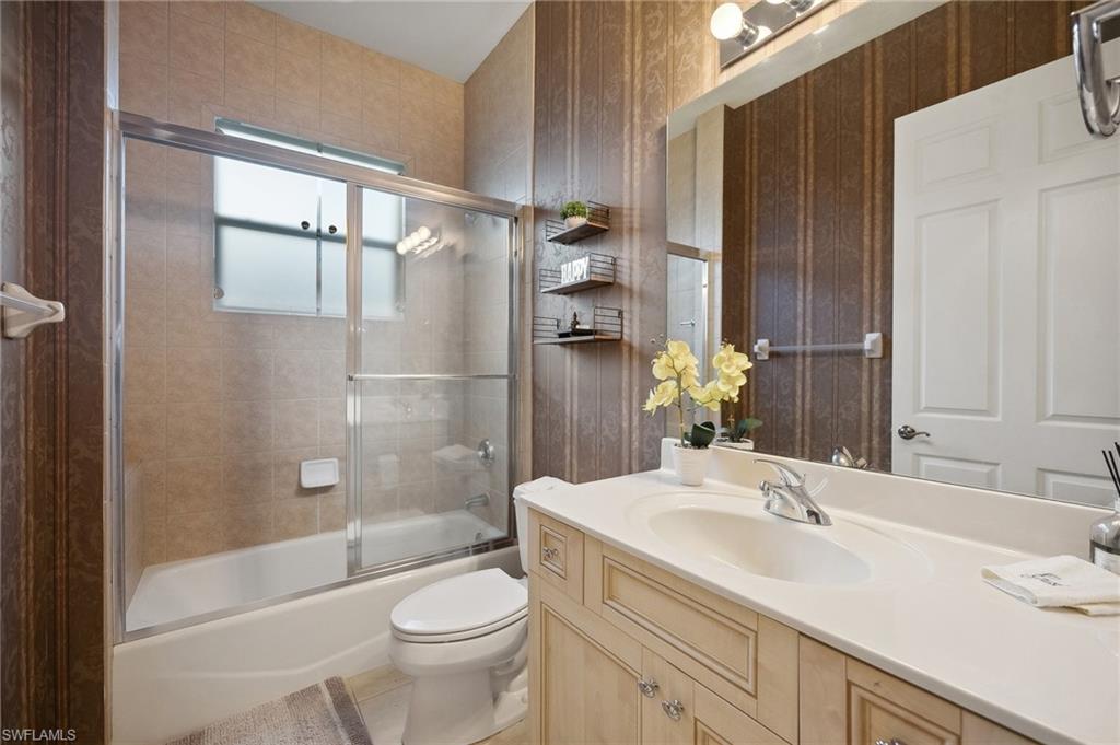 10748 Fieldfair Drive Naples, FL 34119 - Photo 26 of 36 a bathroom with a sink a toilet and shower