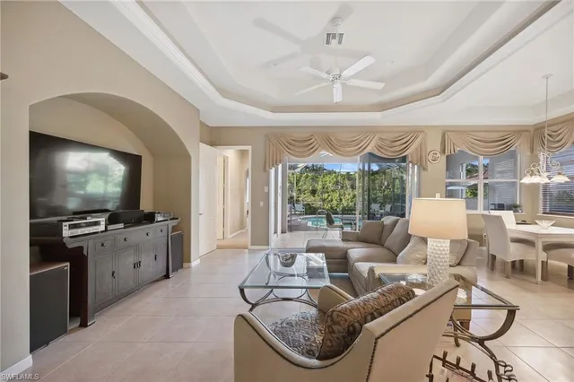 a living room with furniture a flat screen tv and a large window