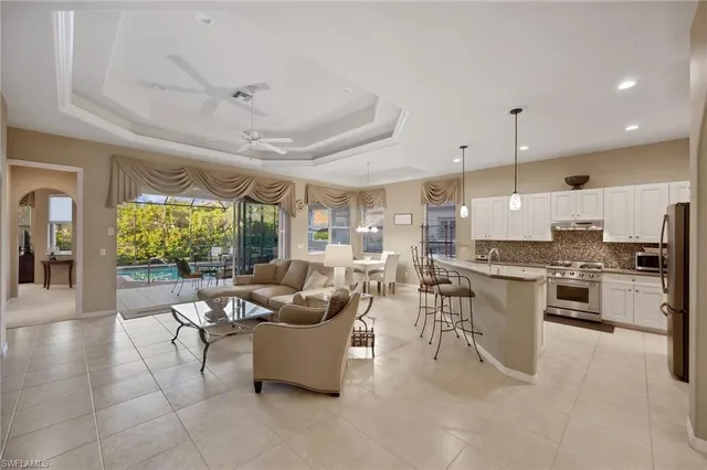 a large living room with stainless steel appliances kitchen island granite countertop furniture and a large window
