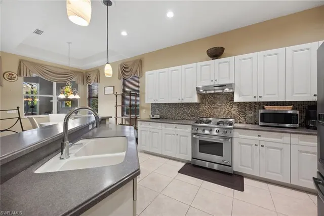 a kitchen with kitchen island granite countertop a sink stainless steel appliances and cabinets