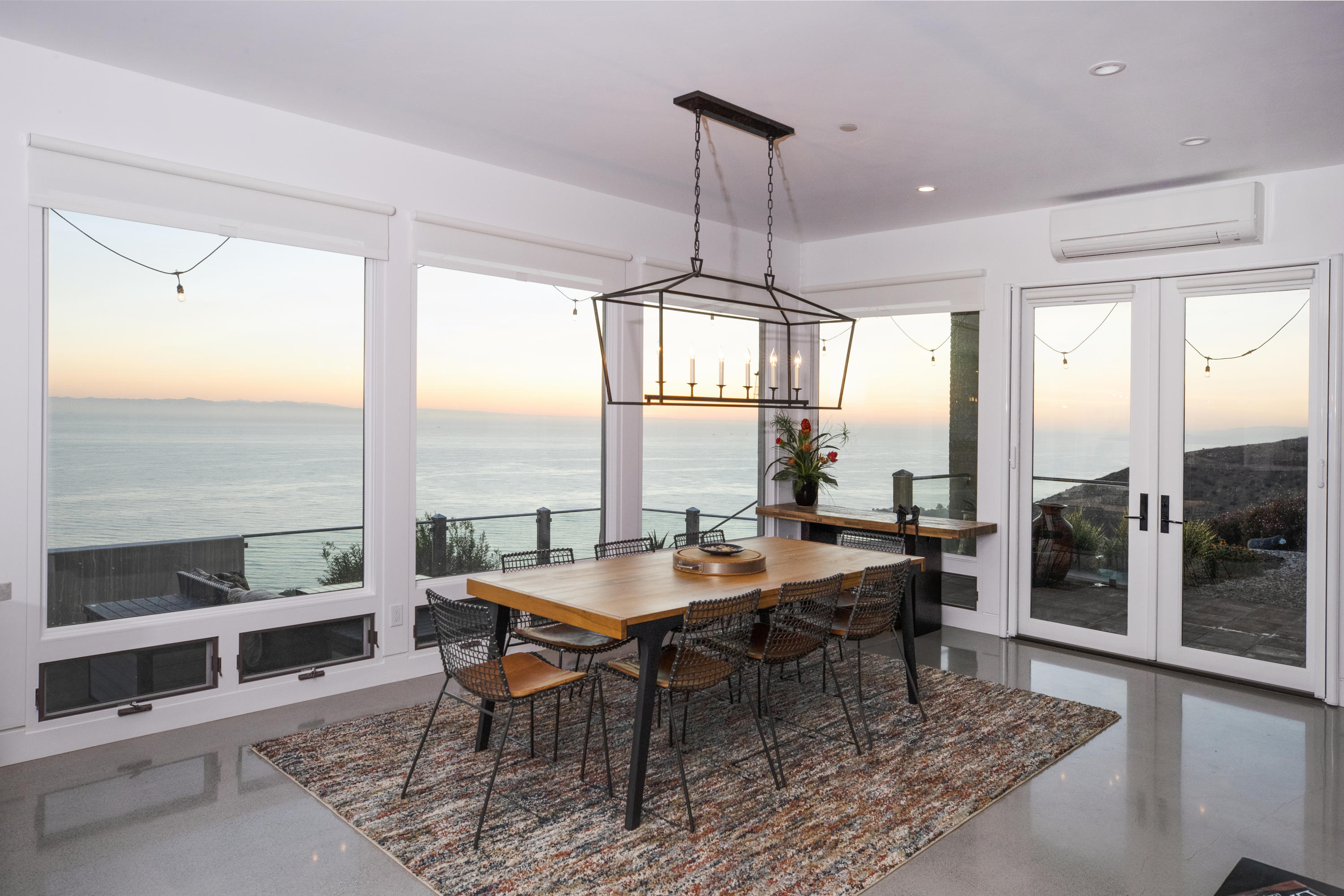 8517 Ocean View Road Ventura, CA 93001 - Photo 16 of 37 a dining room with furniture a chandelier and wooden floor