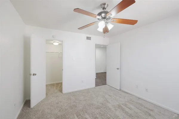 an empty room with a fan and a fan