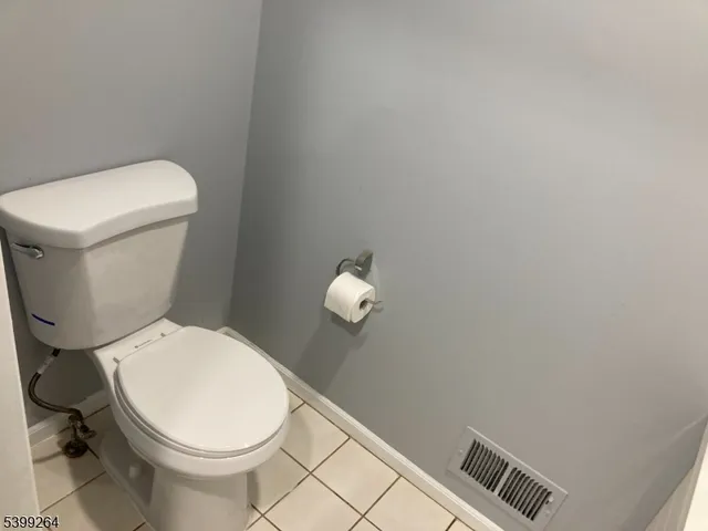 a white toilet sitting next to a white wall