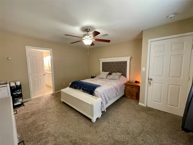 a spacious bedroom with a bed and a chandelier
