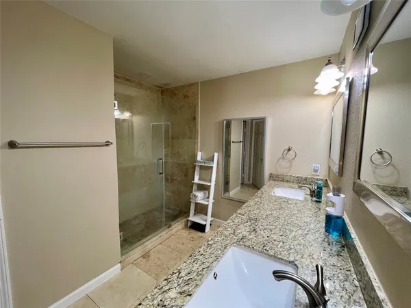 a bathroom with a granite countertop sink a toilet and shower