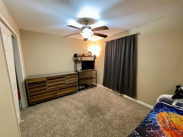 a bedroom with closet and fan