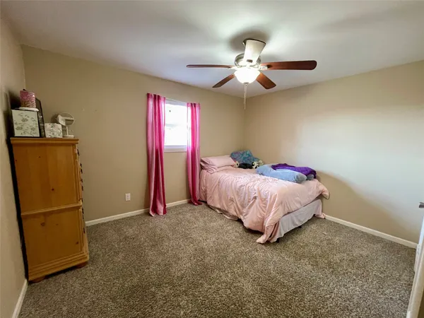 a bed room with a bed and a ceiling fan