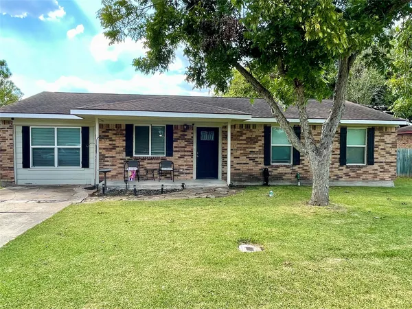 a backyard of a house with yard fire pit and large tree