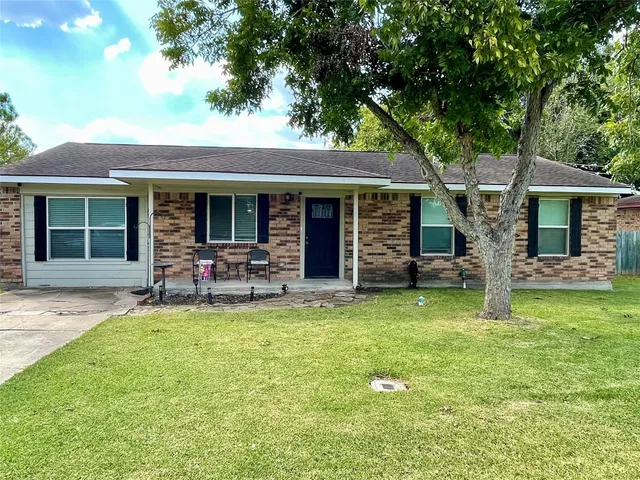 a backyard of a house with yard fire pit and large tree
