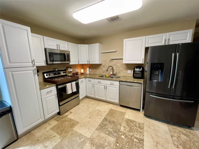 a kitchen with a refrigerator stove and microwave