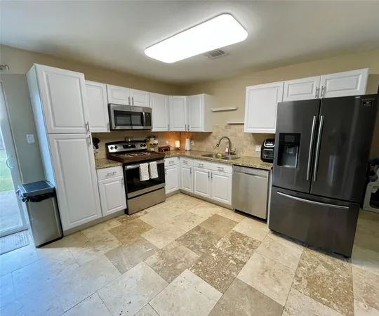 a kitchen with stainless steel appliances and a refrigerator