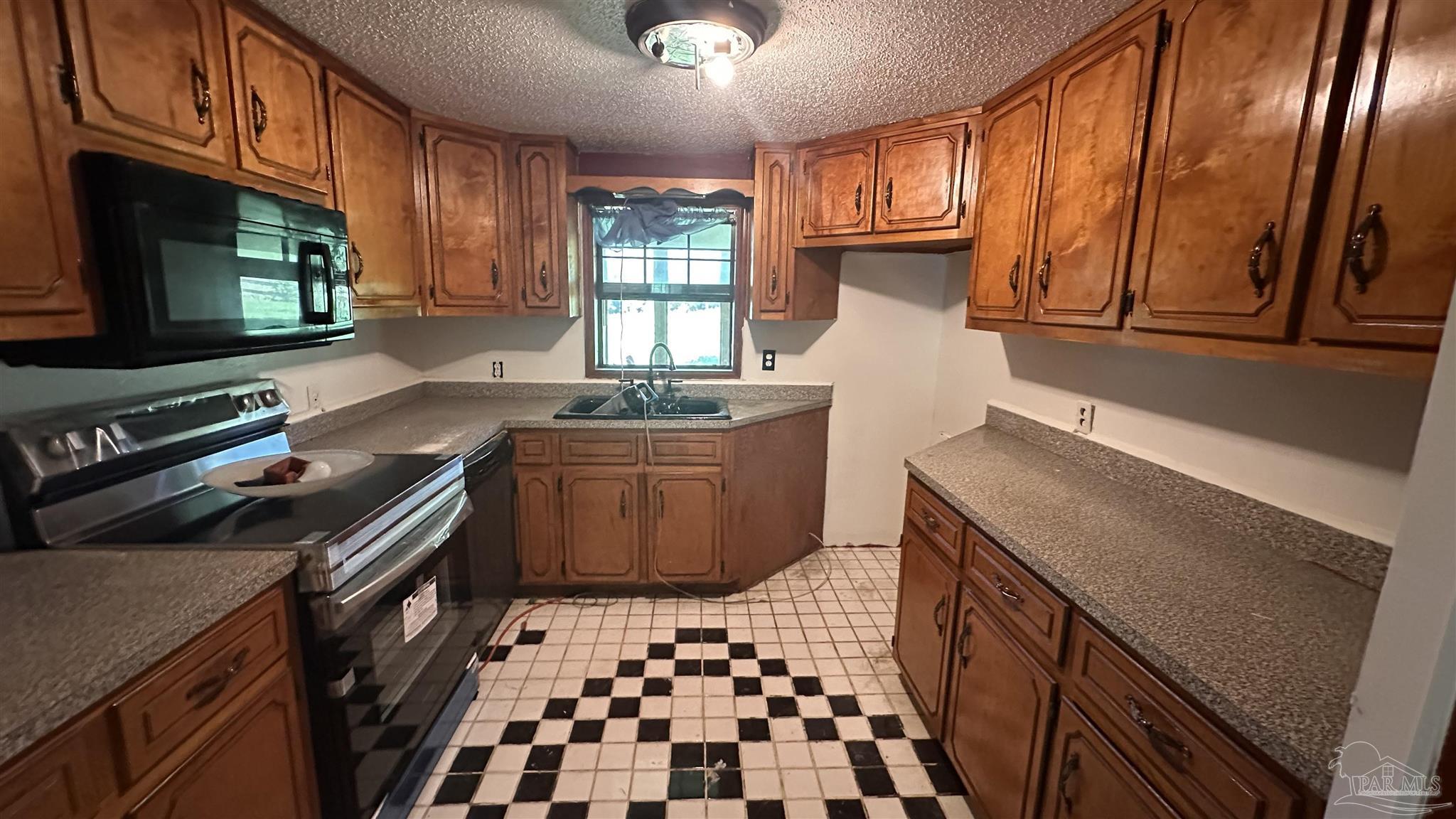 9353 Sellersville Road Jay, FL 32565 - Photo 15 of 26 a kitchen with granite countertop a stove top oven sink and cabinets