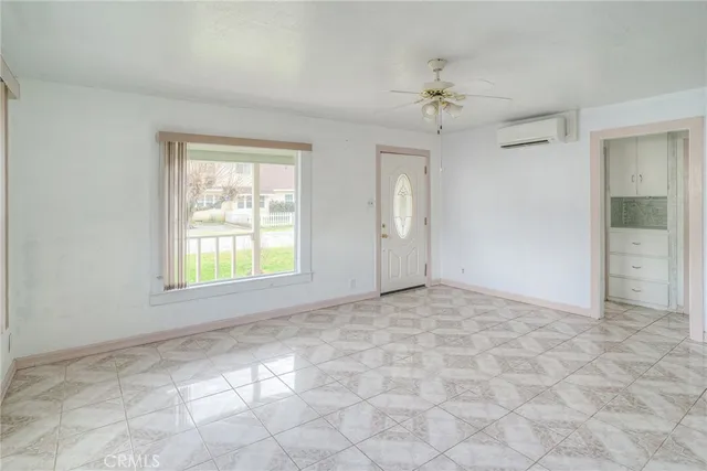 a view of a big room with windows and chandelier fan