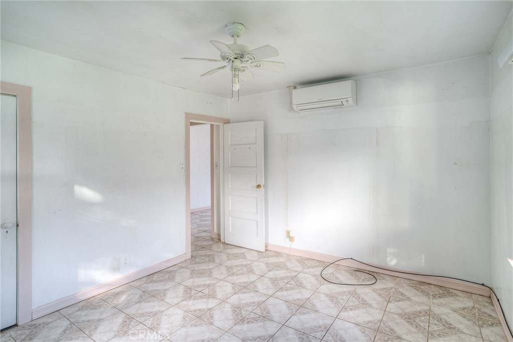 1568 Link Street Corning, CA 96021 - Photo 15 of 28 an empty room with a chandelier fan and windows