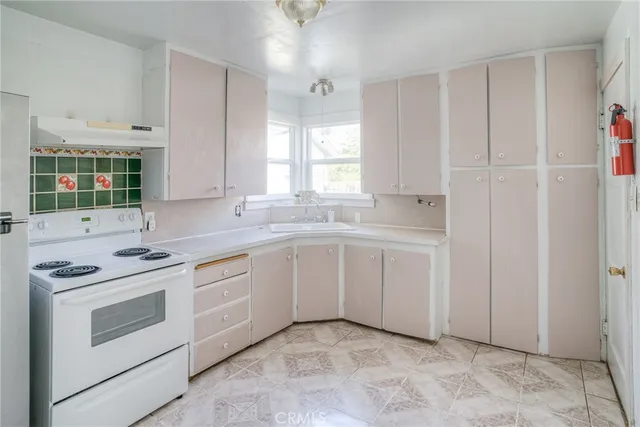a kitchen with white cabinets and white appliances