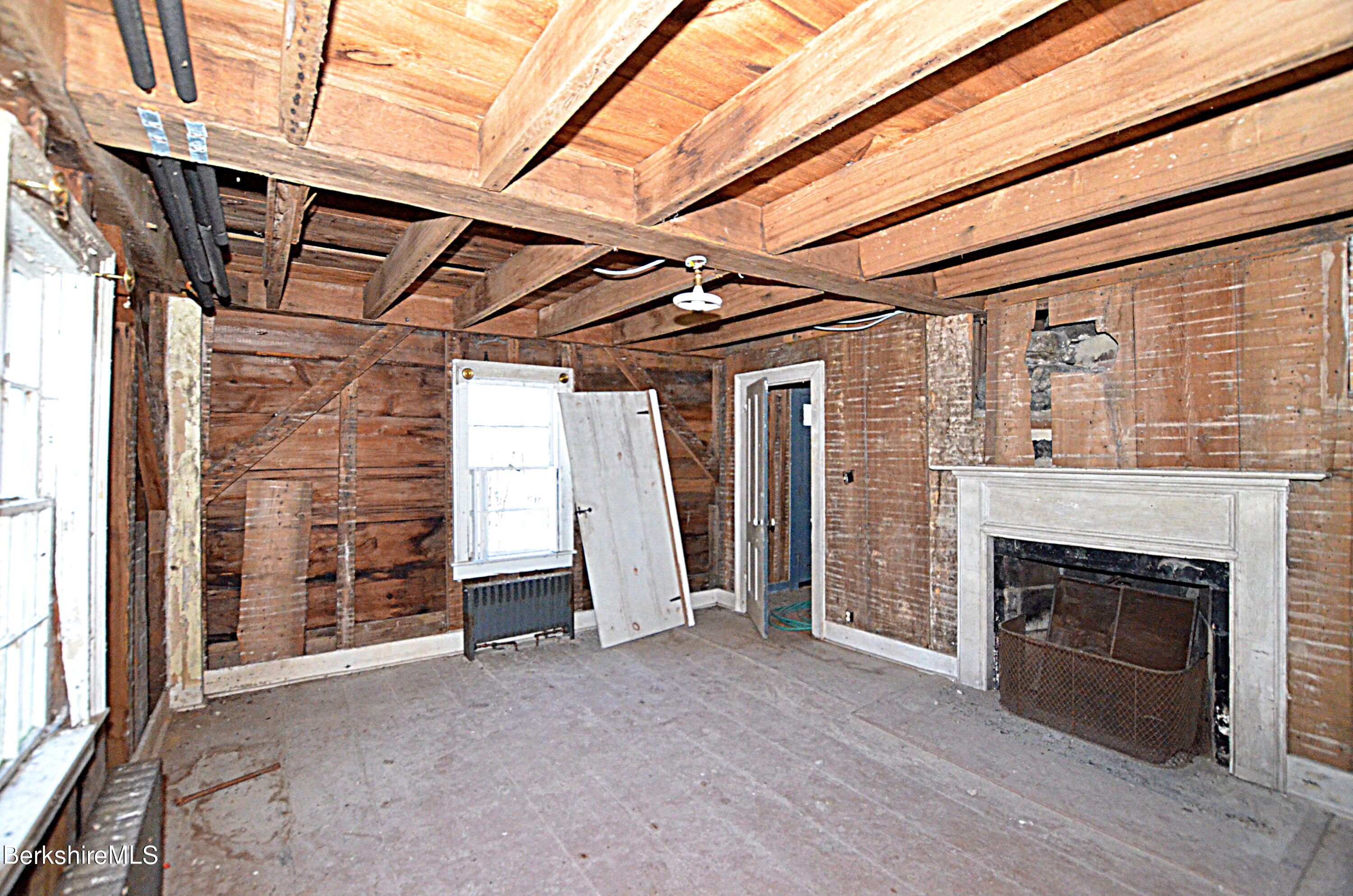 178 New Hartford Road Sandisfield, MA 01255 - Photo 14 of 62 a view of empty room with wooden floor and fireplace