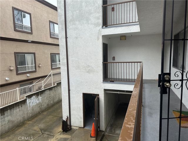 an empty room with wooden floor chandelier and windows