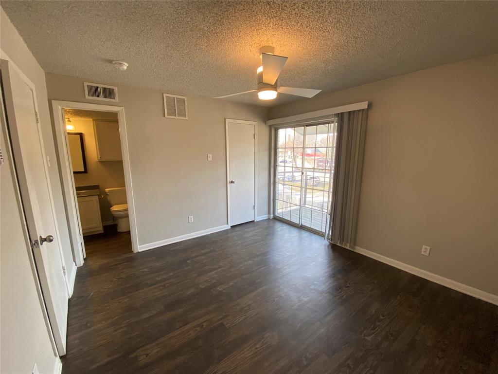 4502 Gaston Avenue, Unit 322 Dallas, TX 75246 - Photo 13 of 17 a view of an empty room with wooden floor and a window