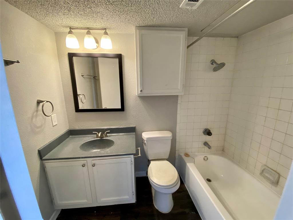 4502 Gaston Avenue, Unit 322 Dallas, TX 75246 - Photo 15 of 17 a bathroom with a toilet sink and mirror