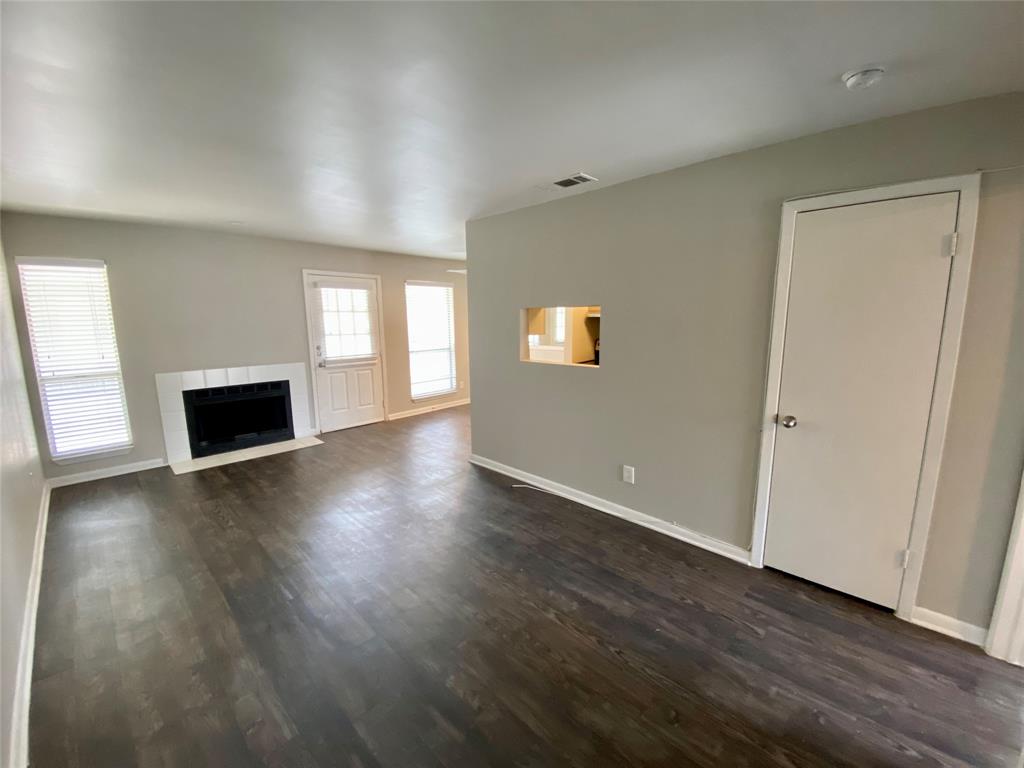 4502 Gaston Avenue, Unit 322 Dallas, TX 75246 - Photo 2 of 17 an empty room with wooden floor and windows