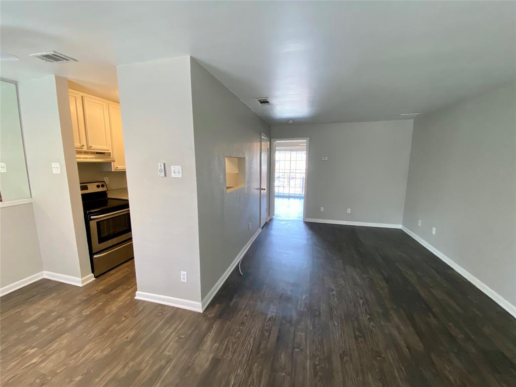 4502 Gaston Avenue, Unit 322 Dallas, TX 75246 - Photo 6 of 17 an empty room with wooden floor and windows