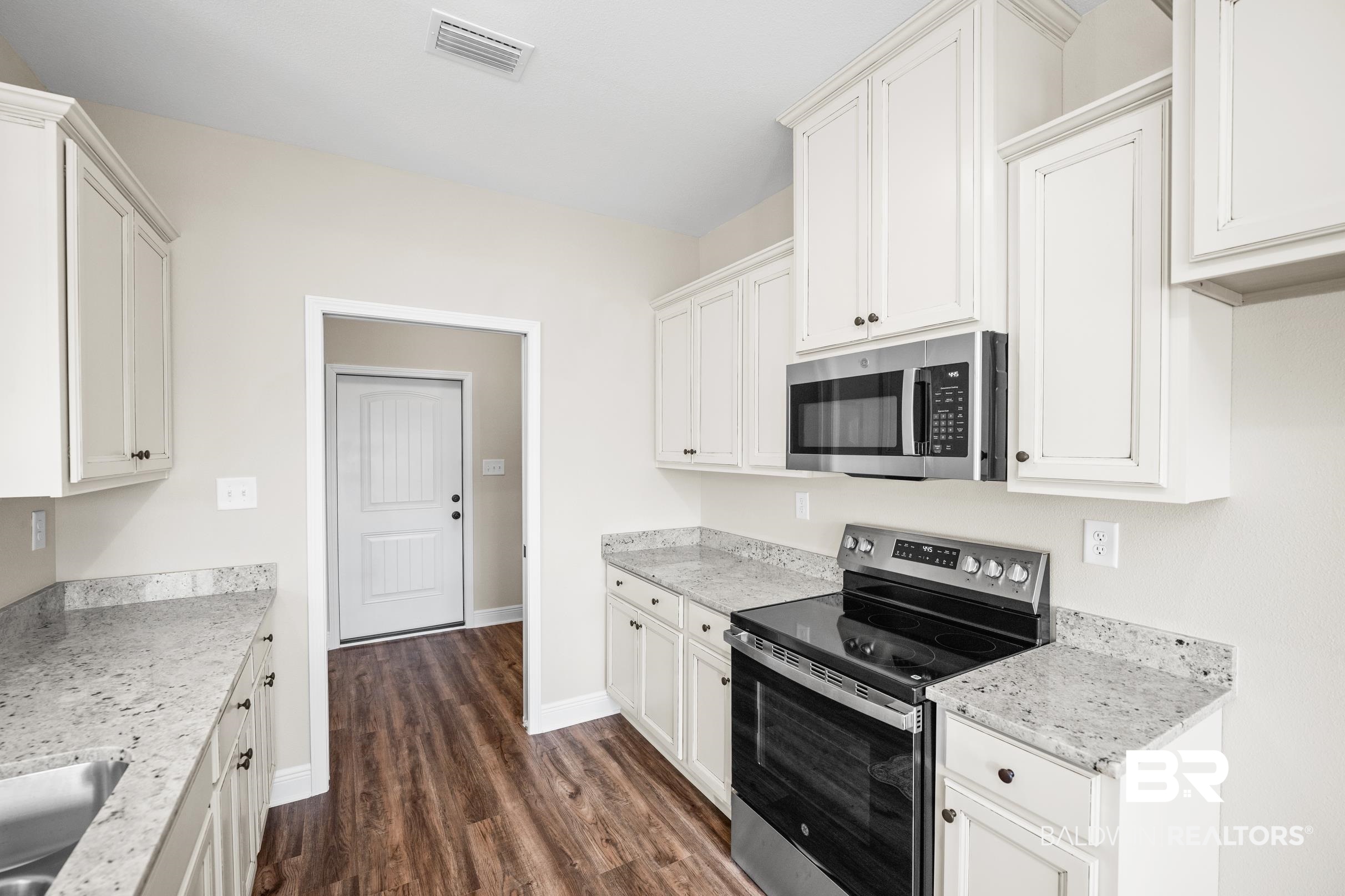 12833 Ward Road West Stapleton, AL 36578 - Photo 8 of 27 Kitchen with appliances with stainless steel finishes, white cabinets, dark wood-style flooring, and light stone counters