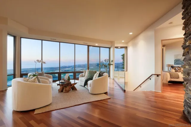a living room with furniture and floor to ceiling windows