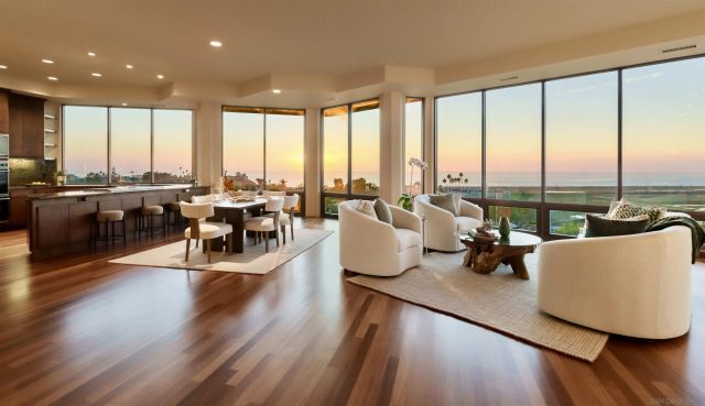 a living room with furniture and floor to ceiling windows
