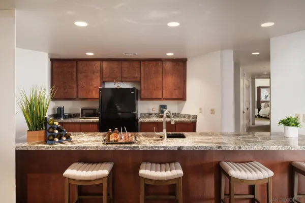 a kitchen with kitchen island granite countertop a sink and a stove
