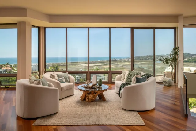 a living room with furniture and floor to ceiling windows