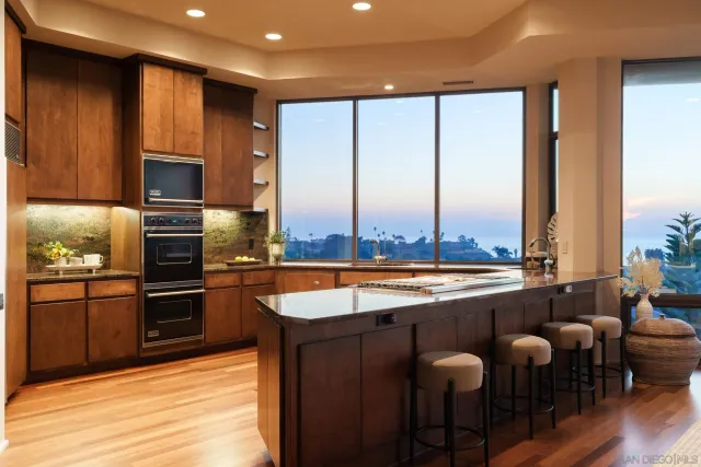 a large kitchen with a large window and stainless steel appliances