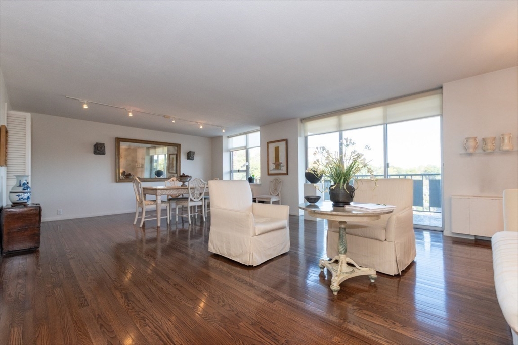 280 Boylston Street, Unit 710 Newton, MA 02467 - Photo 9 of 32 a living room with furniture a wooden floor and a large window