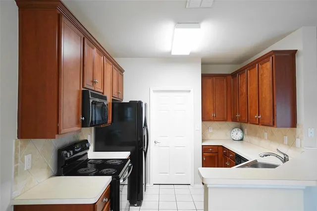 a kitchen with a sink a refrigerator and cabinets